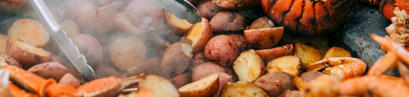 up close photo of a seafood boil with lobster crab shrimp and potatoes